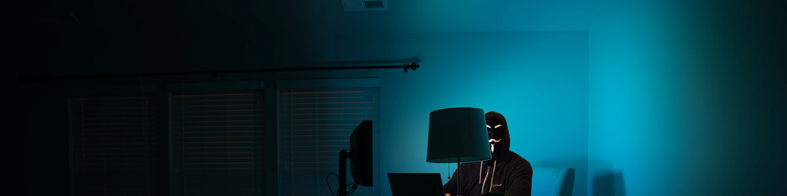 Security tester working alone in a dark, teal-lit room