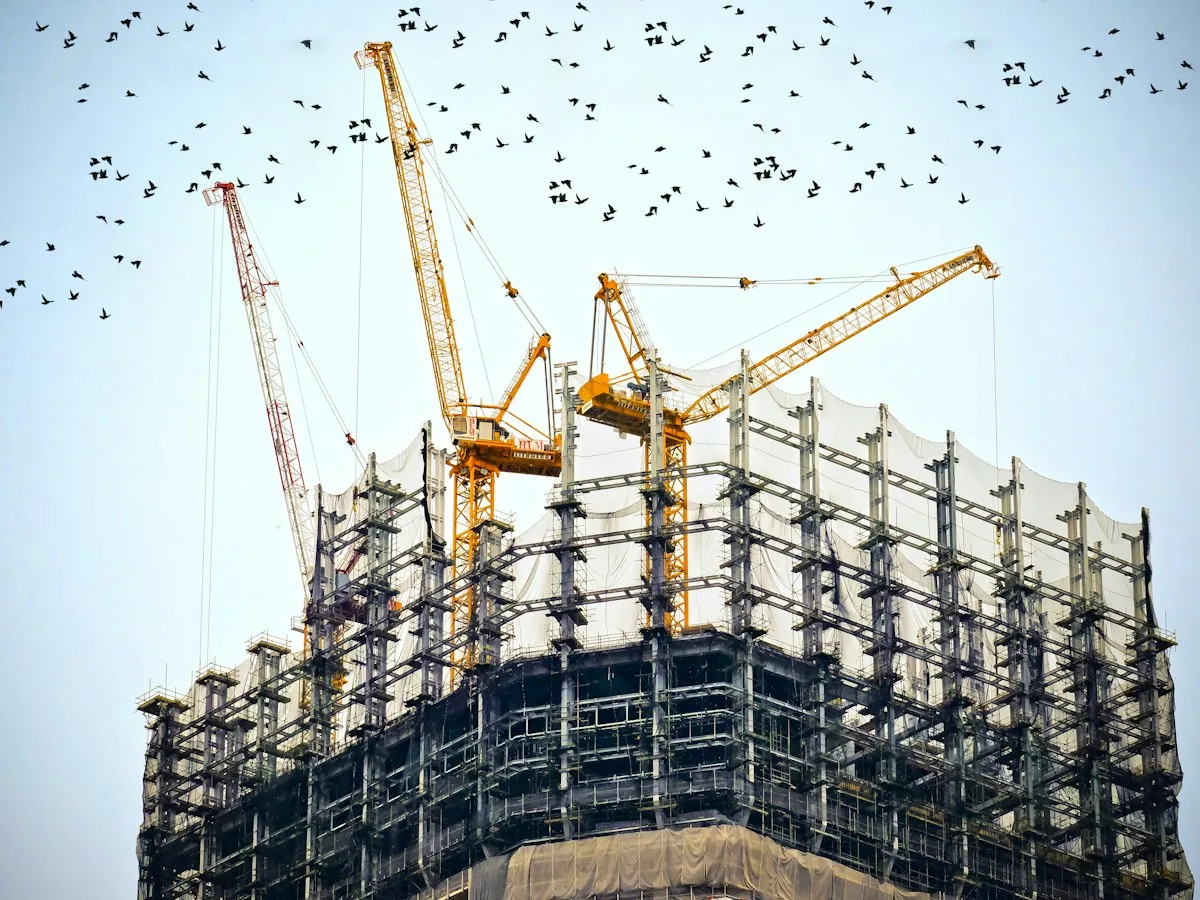 High-rise building under construction with tower cranes